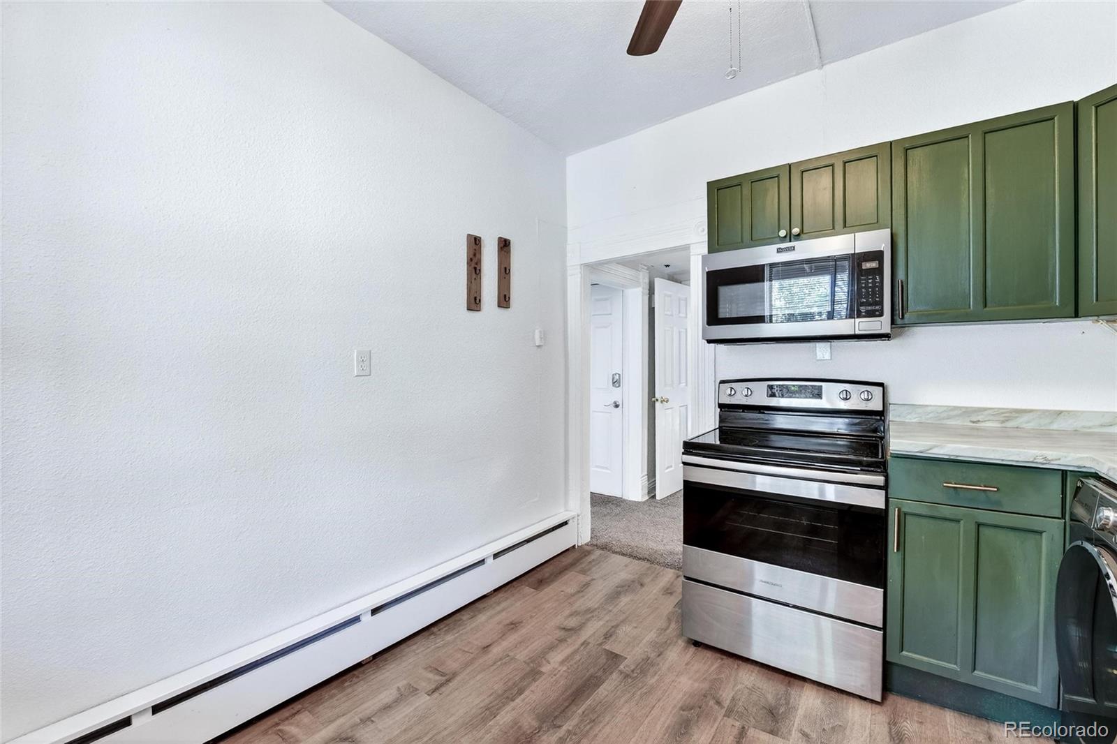 3127 West 28th Avenue, Unit 2 Denver, CO 80211 - Photo 14 of 30 a kitchen with granite countertop cabinets stainless steel appliances and wooden floor