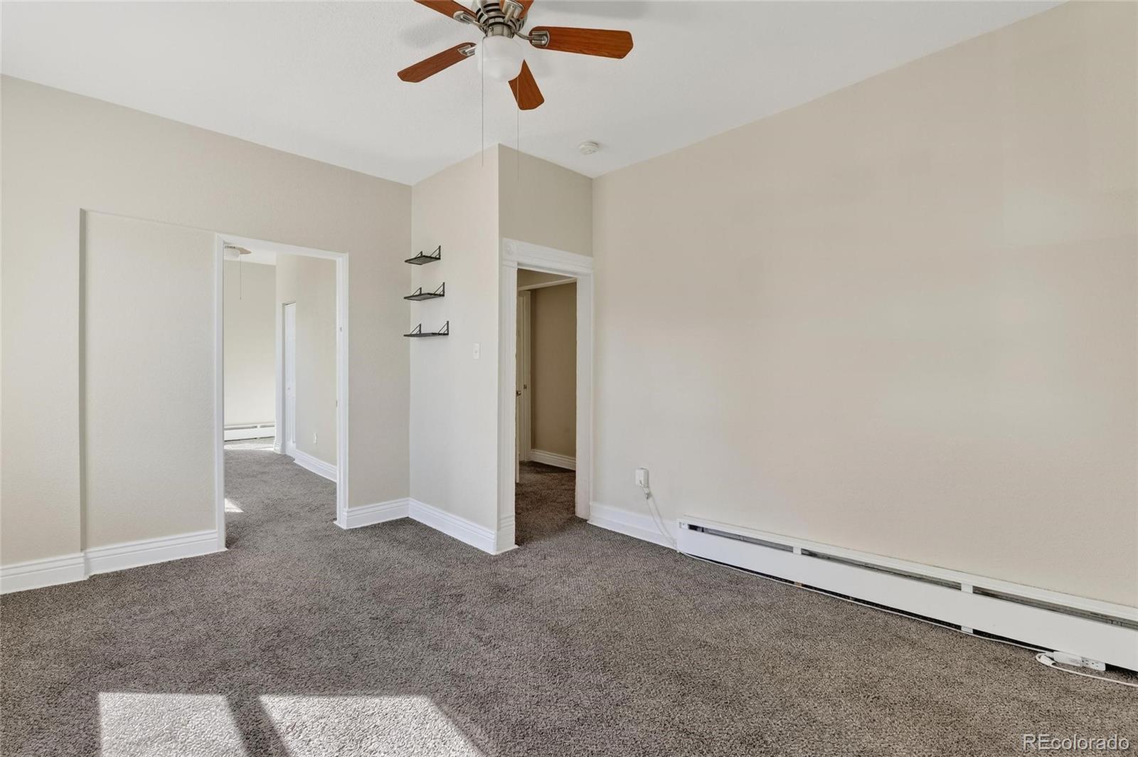 3127 West 28th Avenue, Unit 2 Denver, CO 80211 - Photo 23 of 30 an empty room with a ceiling fan and carpet