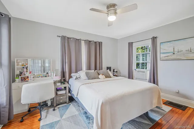 a bedroom with a bed desk and a window