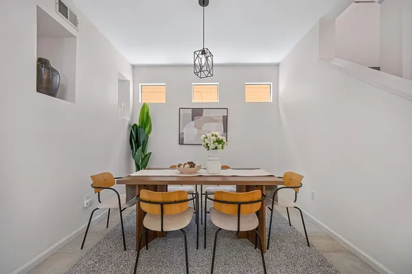 a living room with furniture kitchen view and large windows