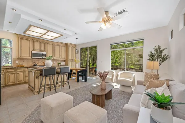 a kitchen with stainless steel appliances a table chairs refrigerator and cabinets