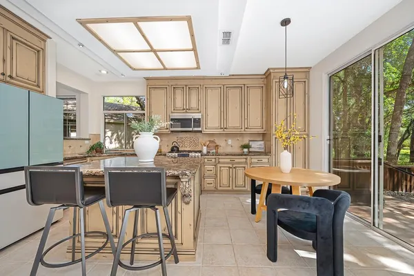 a kitchen with stainless steel appliances granite countertop white cabinets a sink dishwasher and a stove