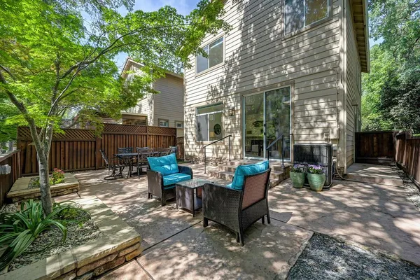 a view of backyard with outdoor seating a patio and plants
