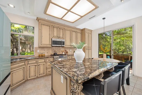 a kitchen with a stove a table and chairs in it