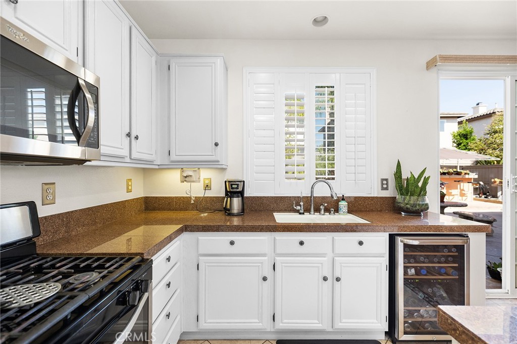 1427 Marble Canyon Way Chula Vista, CA 91915 - Photo 17 of 60 a kitchen with granite countertop a stove a sink and a cabinets