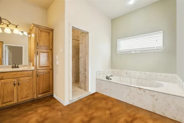 a bathroom with a tub sink shower and mirror