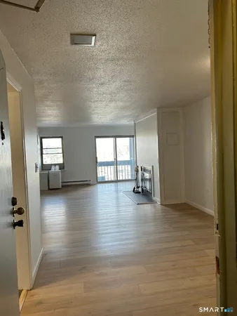 a view of empty room with wooden floor