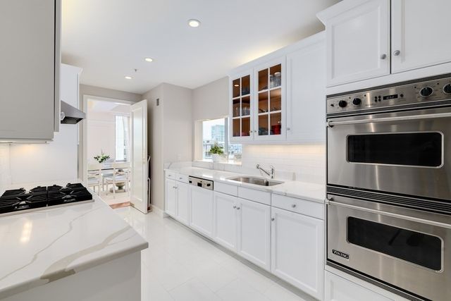 a kitchen with stainless steel appliances a stove a sink and cabinets