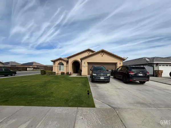 a car parked in front of a house with a yard