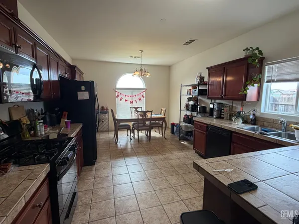 a kitchen with stainless steel appliances granite countertop a stove top oven a sink dishwasher and cabinets