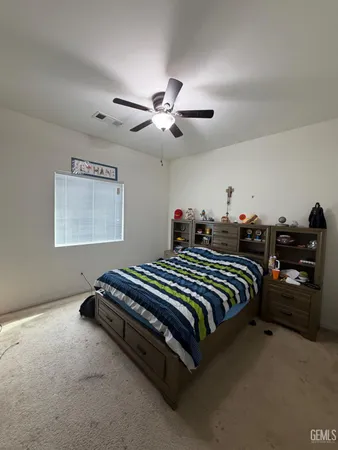 a spacious bedroom with a bed and a ceiling fan