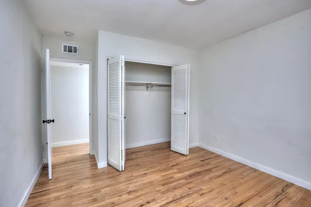 an empty room with wooden floor and a window
