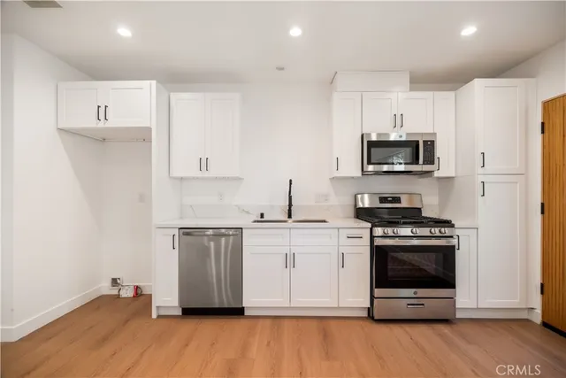 a kitchen with stainless steel appliances a stove a sink and a microwave