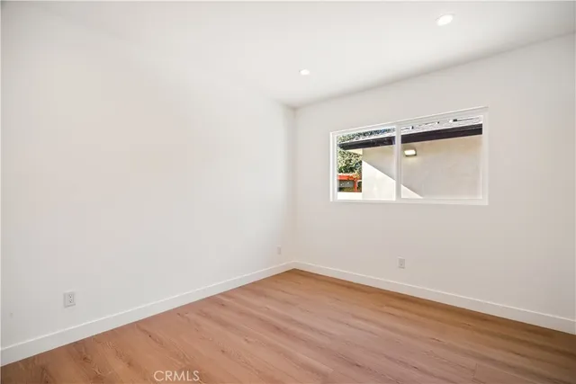 an empty room with wooden floor and a window