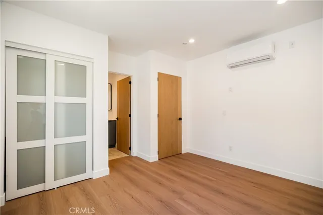 an empty room with wooden floor and closet