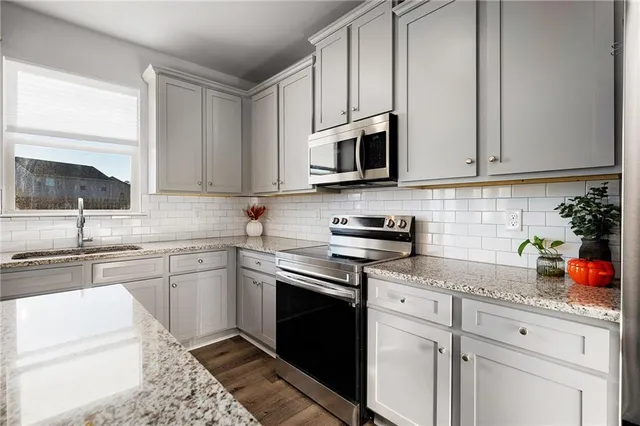 a kitchen with stainless steel appliances granite countertop a sink stove and cabinets