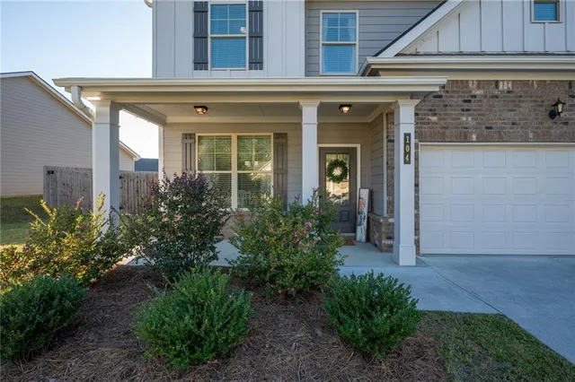a view of a house with potted plants and a bench