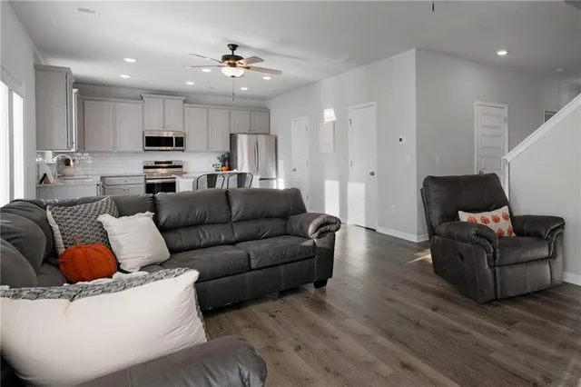 a living room with furniture and a view of kitchen