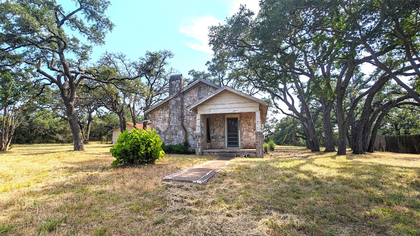 a view of a house with a yard and tree s
