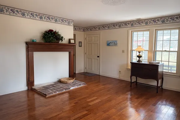 a view of a livingroom with wooden floor and a fireplace