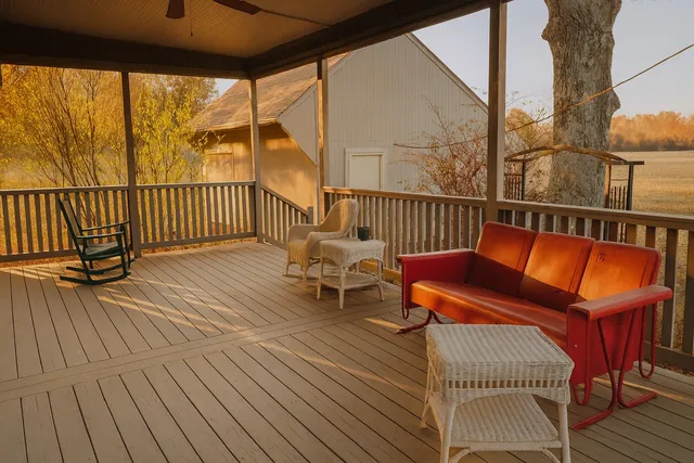 a balcony with wooden floor table and chairs