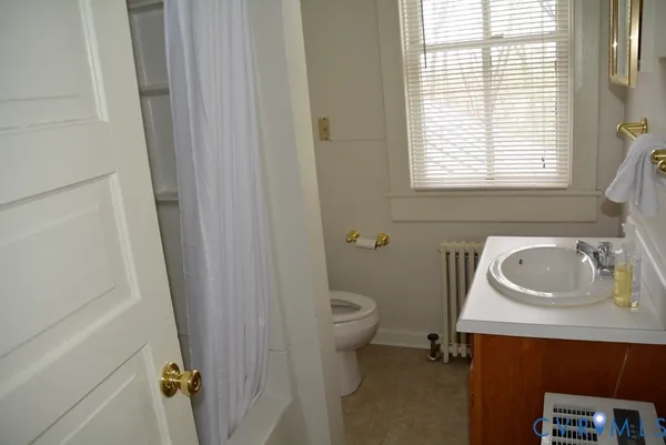 a bathroom with a sink a toilet and a window