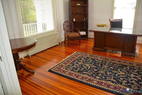 a living room with rug floor to ceiling window and wooden floor