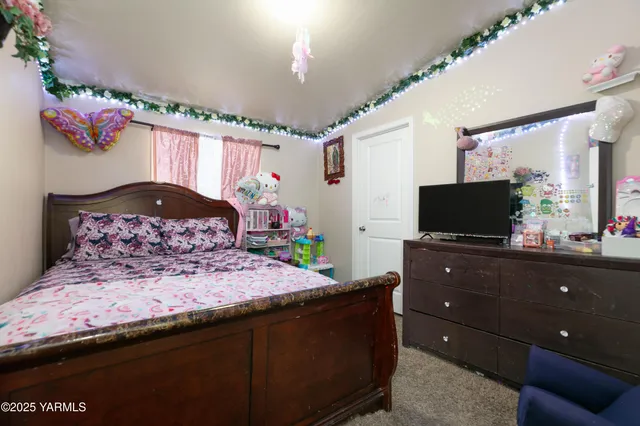 a bedroom with a bed and a flat screen tv