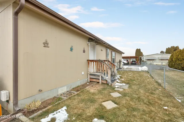 a backyard of a house with table and chairs