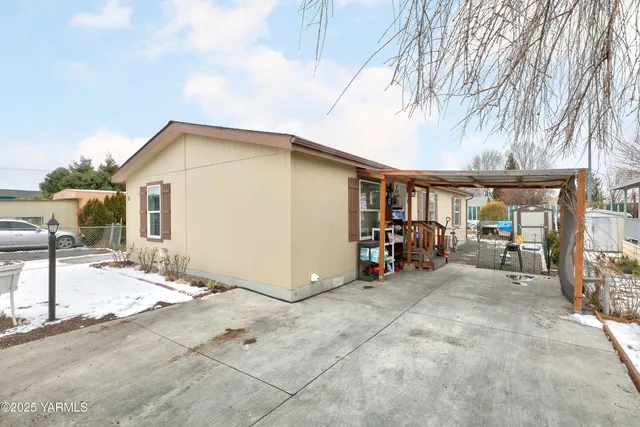 a view of a house with large trees and playing area