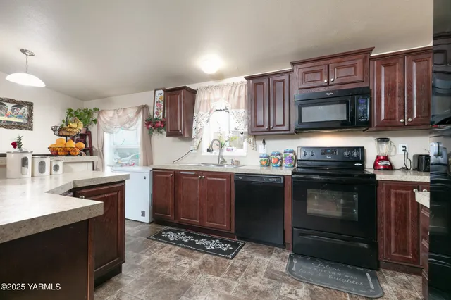 a kitchen with granite countertop wooden cabinets and stainless steel appliances