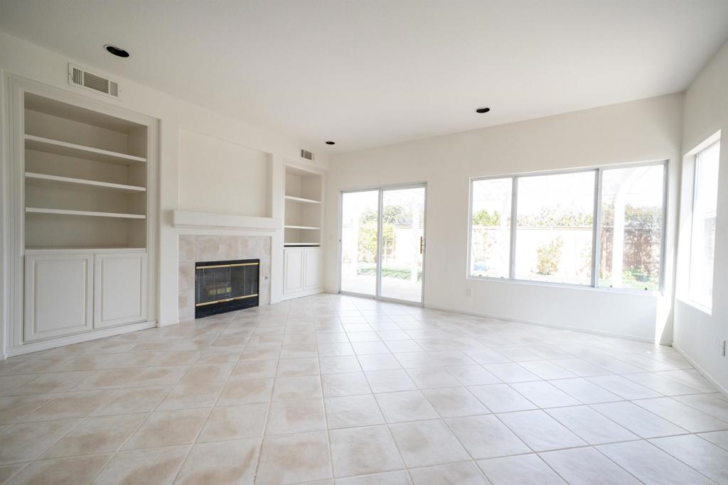 5210 Candlelight Street Oceanside, CA 92056 - Photo 11 of 30 a view of an empty room with a fireplace and a window