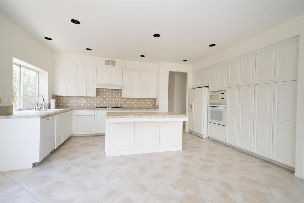 5210 Candlelight Street Oceanside, CA 92056 - Photo 13 of 30 a large white kitchen with white cabinets