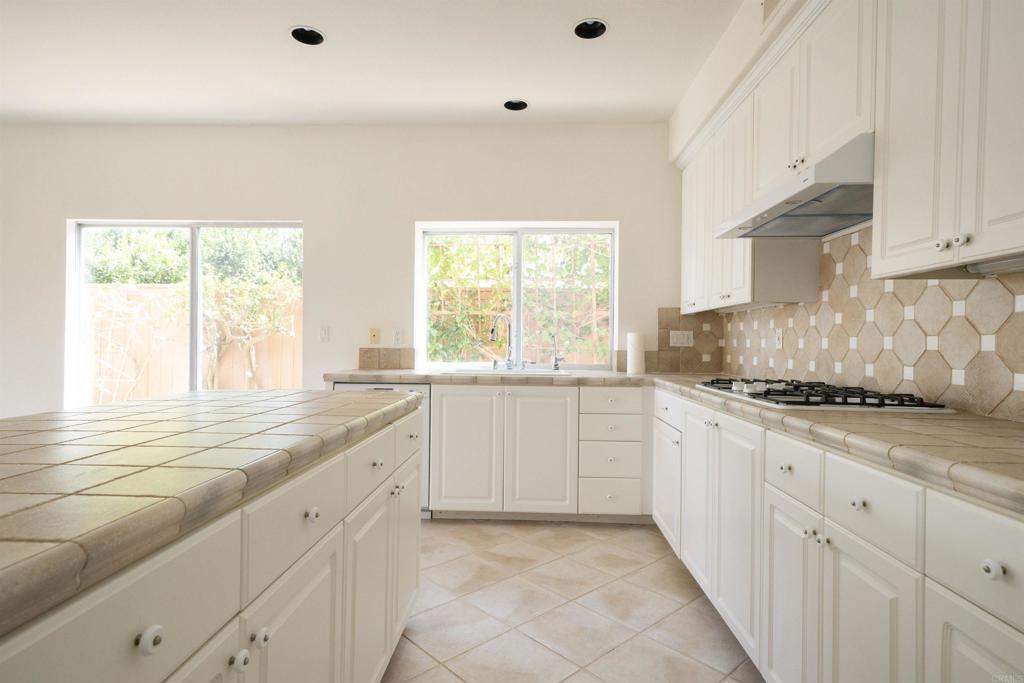 5210 Candlelight Street Oceanside, CA 92056 - Photo 14 of 30 a kitchen with granite countertop white cabinets and white appliances
