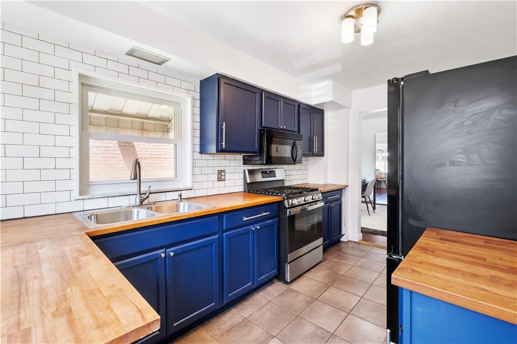 4088 Howley Street Pittsburgh, PA 15224 - Photo 12 of 32 a kitchen with stainless steel appliances granite countertop a sink stove and refrigerator