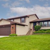 a front view of a house with a garden and plants