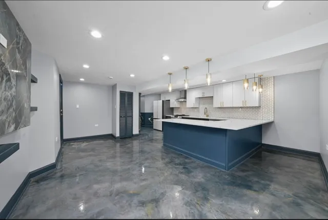 a large kitchen with kitchen island a sink stainless steel appliances and cabinets