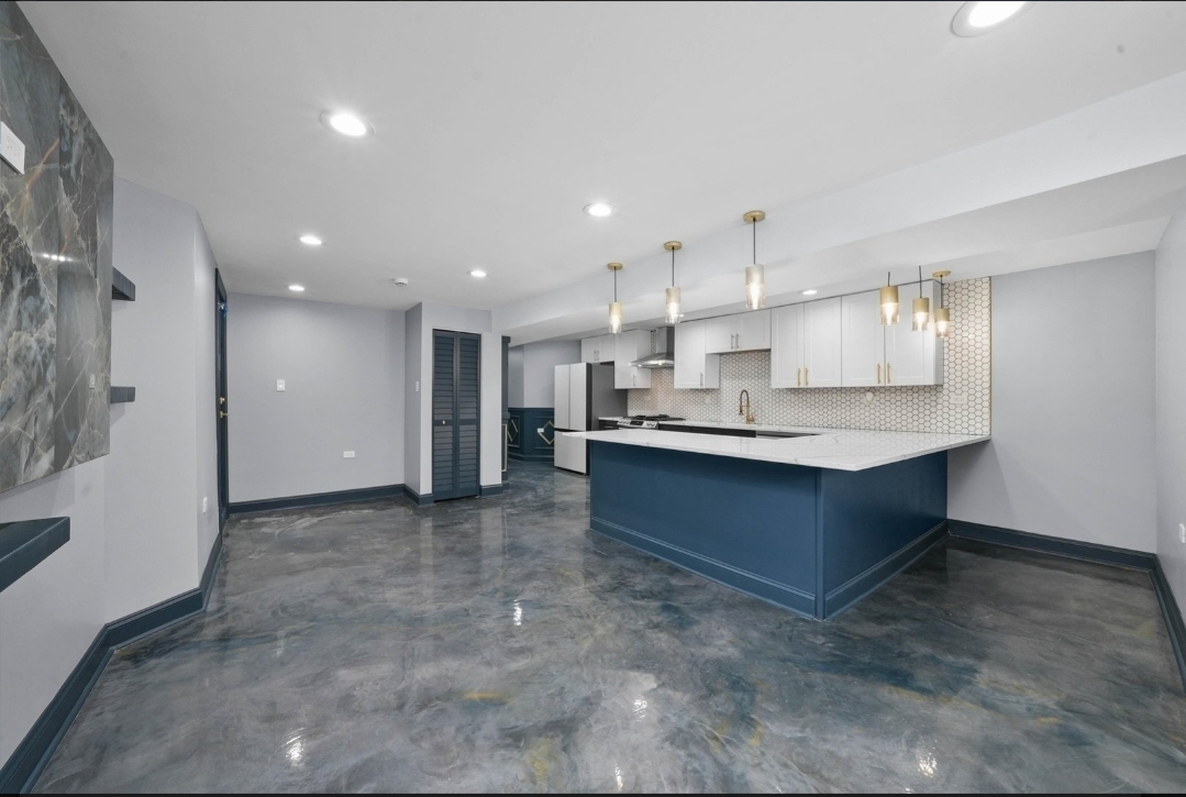 1526 South St Louis Avenue, Unit G Chicago, IL 60623 - Photo 7 of 13 a large kitchen with kitchen island a sink stainless steel appliances and cabinets