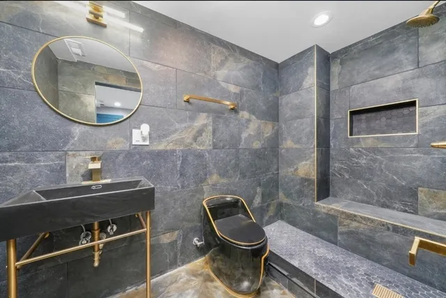 a bathroom with a toilet a sink and mirror