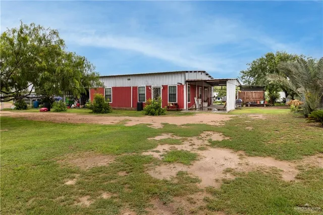 a view of a house with a big yard and large trees