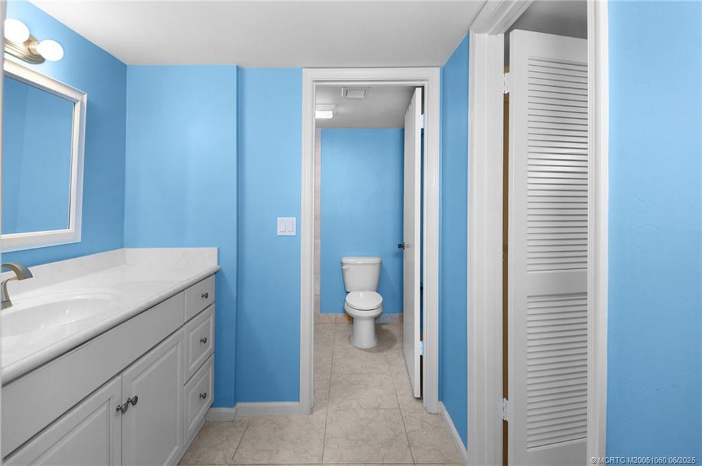 3100 Southeast Pruitt Road, Unit B105 Port St. Lucie, FL 34952 - Photo 15 of 40 a bathroom with a granite countertop sink and a toilet