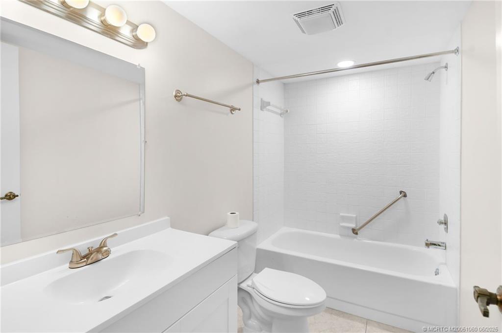 3100 Southeast Pruitt Road, Unit B105 Port St. Lucie, FL 34952 - Photo 21 of 40 a bathroom with a sink mirror vanity and toilet