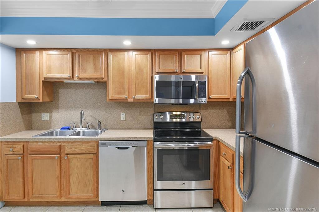 3100 Southeast Pruitt Road, Unit B105 Port St. Lucie, FL 34952 - Photo 6 of 40 a kitchen with stainless steel appliances a refrigerator stove and microwave