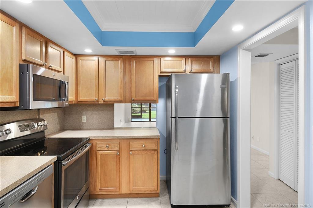 3100 Southeast Pruitt Road, Unit B105 Port St. Lucie, FL 34952 - Photo 7 of 40 a kitchen with stainless steel appliances granite countertop a refrigerator a stove top oven a sink and dishwasher