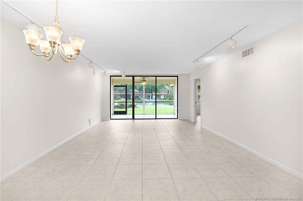 3100 Southeast Pruitt Road, Unit B105 Port St. Lucie, FL 34952 - Photo 8 of 40 a view of an empty room with a chandelier fan
