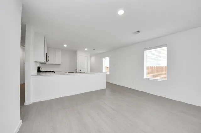 a view of kitchen with kitchen island white cabinets and stainless steel appliances