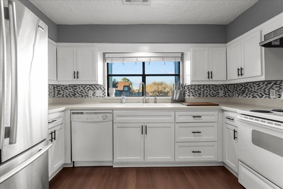 671 Davis Road League City, TX 77573 - Photo 17 of 38 a kitchen with white cabinets and white appliances
