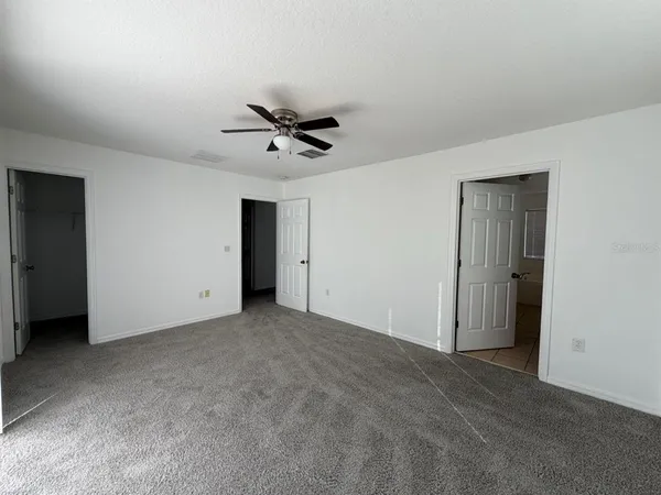 a view of an empty room with a ceiling fan