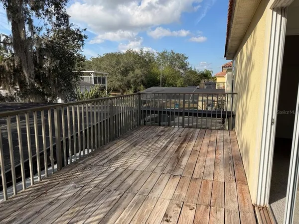a view of a balcony with wooden floor and fence
