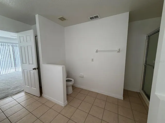 a bathroom with a toilet and a shower